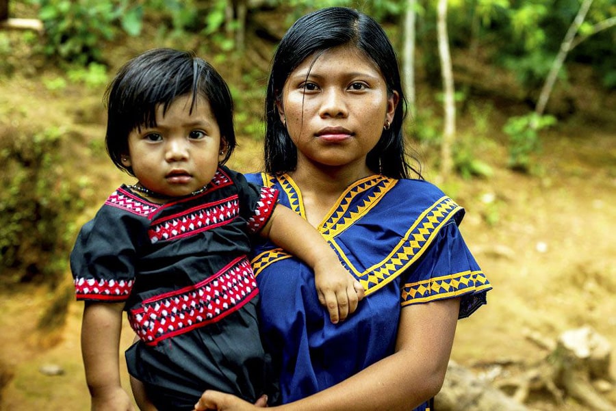 A Ngäbe Woman with her child dressed in traditional style Ngäbe clothing