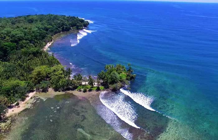 Arial view of old mans surf spot and carenero point in bocas del toro, panama, with blue water and jungle.