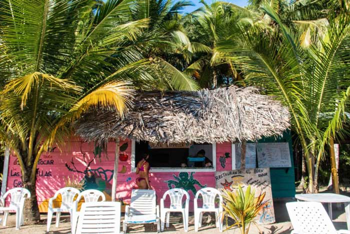 A woman orders a drink at a pink beach restaurant at Starfish Beach which is one of the most popular things to do in Bocas del Toro