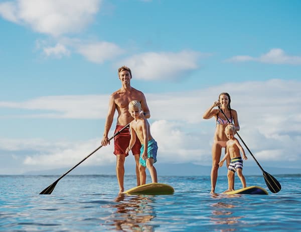 overwater bungalow family on paddle boards