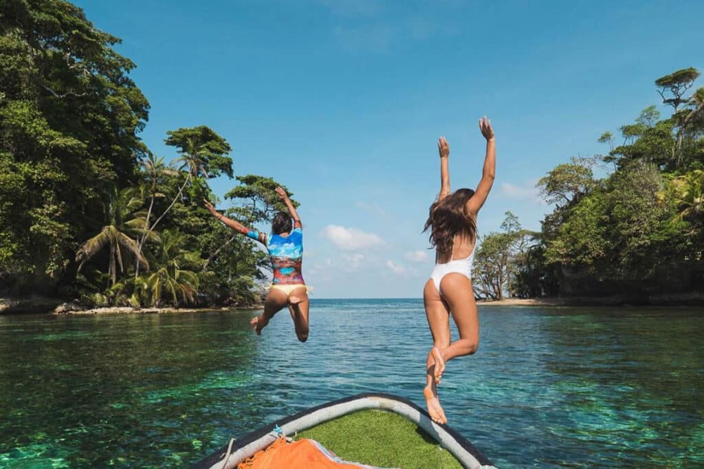 bird island women jumping into water from mono loco surf school in Bocas del Toro Panama