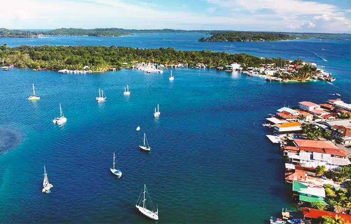 Drone view of sailboats and blue water above bocas town, isla carenero, isla bastimentos, and isla solarte in bocas del toro panama.