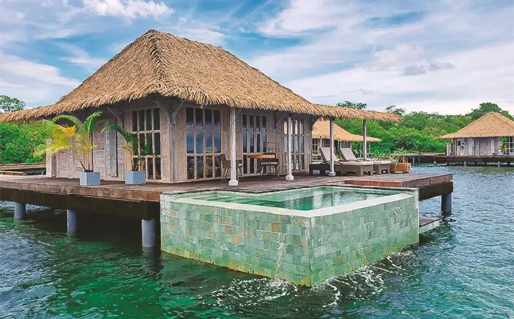 Bocas Bali overwater bungalow with plunge pool and thatch roof in Bocas del Toro, Panama.
