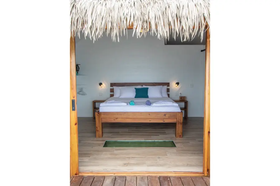 A view looking in from the deck to the king size bed of a bungalow in Bocas del Toro.
