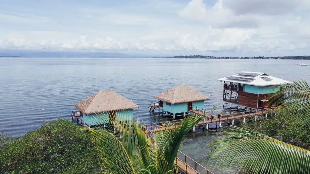 The hero image for the Sol Bungalows website shows the two blue overwater bungalows and the restaurant area with a beautiful view of the Bocas del Toro Archipelago in Panama.