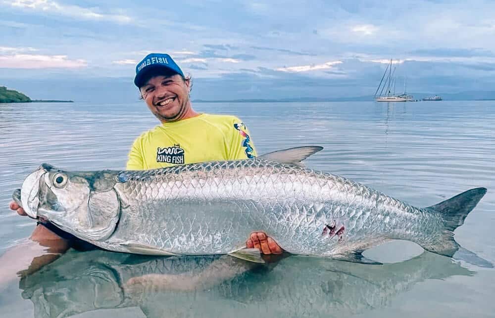 A man holds a tarpon he caught while sportfishing in Bocas del Toro Panama.