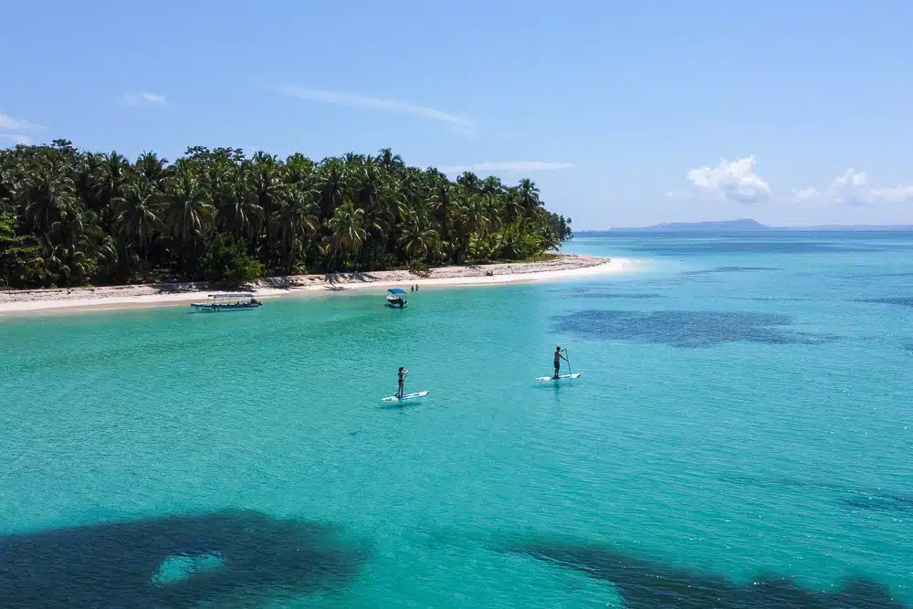 Isla Zapatilla with paddle boarders and clear turquoise water.