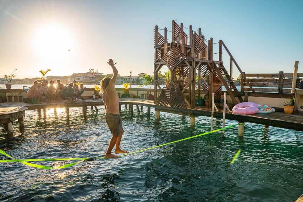 A man balances on a slack line over the water at Aqua Lounge in Bocas del Toro.