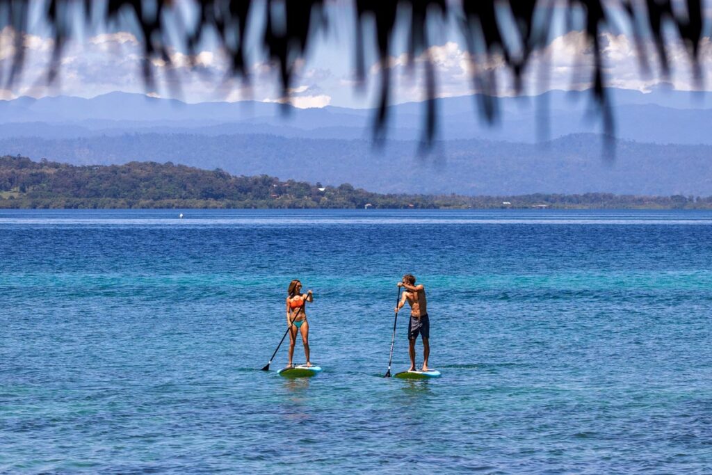 Go paddle boarding in the turquoise waters surround Isla Solarte while staying in an affordable overwater bungalow in Panama